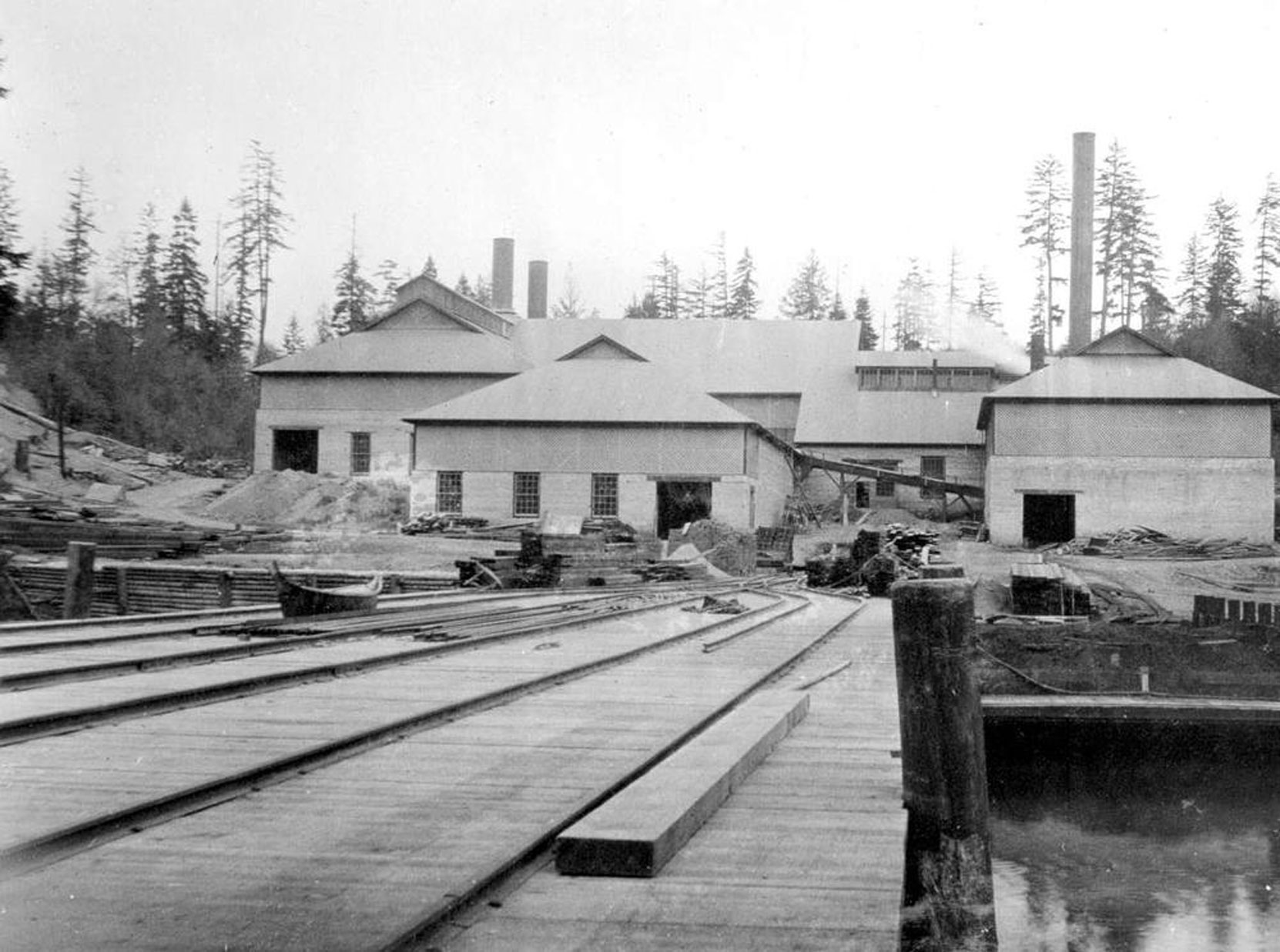 BC Ministry of Mines photo of the Vancouver Portland cement Company plant at Tod Inlet, circa 1904. Note the aboriginal canoe on the wharf. (BC Archives photo I-56386)