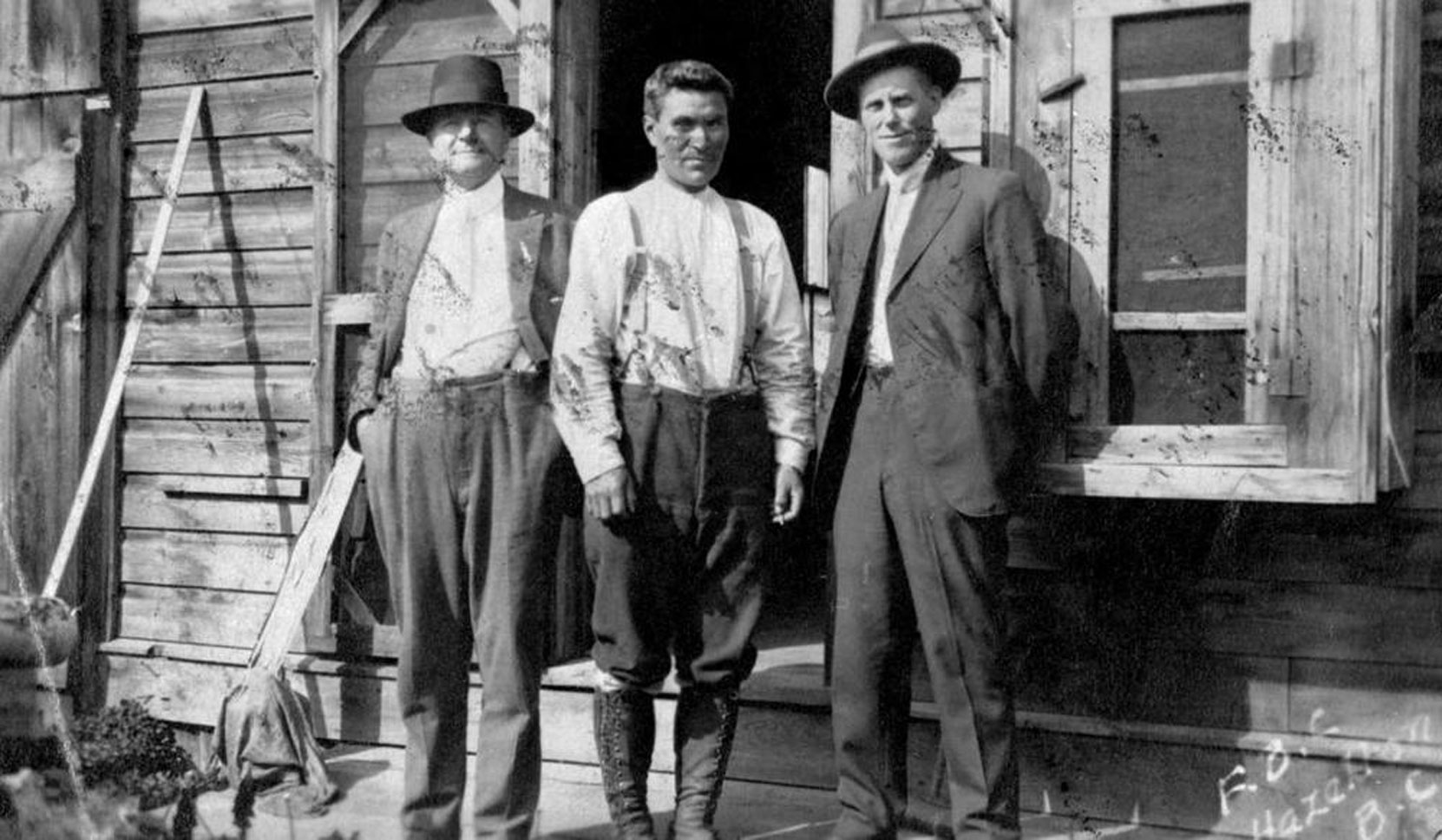 Stuart Alexander Henderson (left), Simon Gunanoot (center) in Hazelton during Simon Gunanoot's murder trial, 1919 (BC Archives photo F-03836)