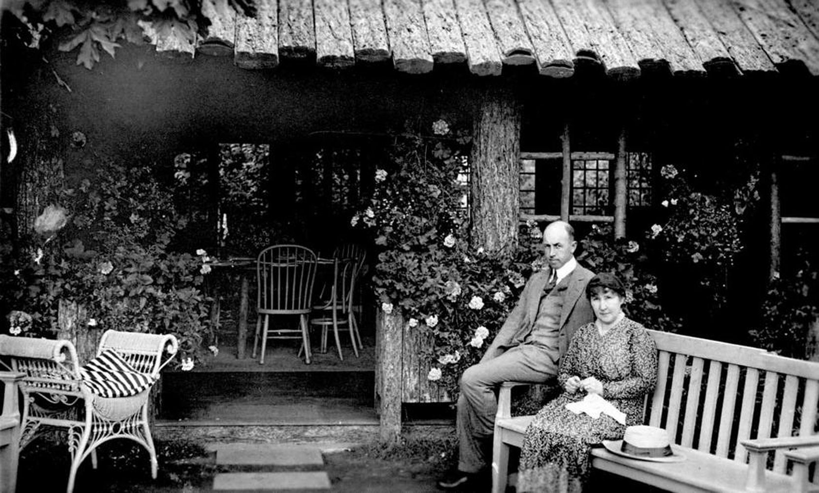 Jenny Butchart with her son in law William Todd at Benvenuto, circa 1920. The building in the background is likely the teahouse which once stood near the entrance to the Japanese Garden. [BC Archives photo E-04311]
